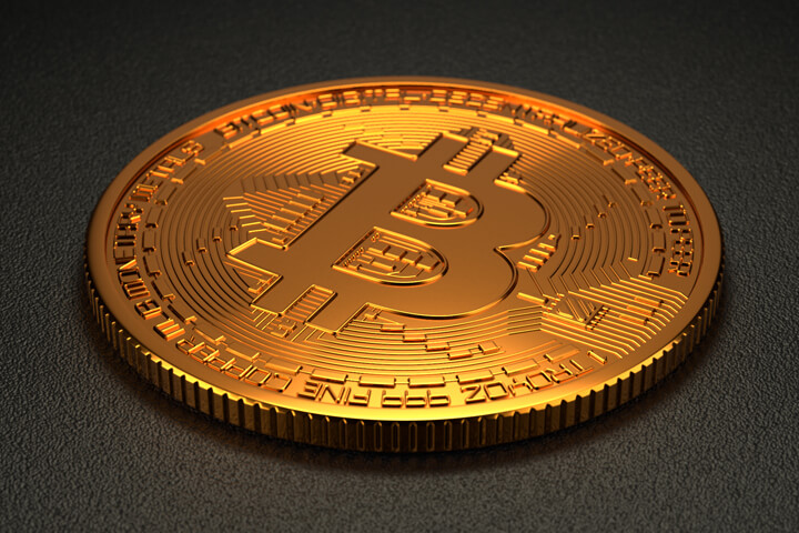 Single Bitcoin on dark background with soft light