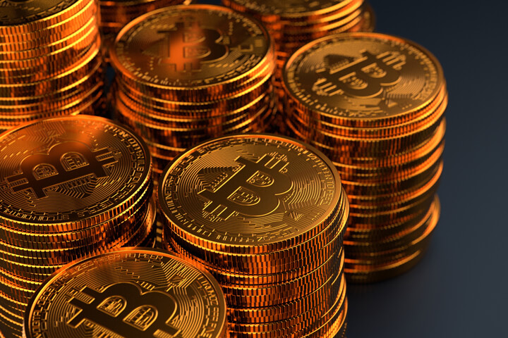 Multiple stacks of Bitcoins on dark background with stacks exiting left side of frame