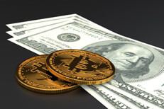 Two Bitcoins laid on three one hundred dollar bills
