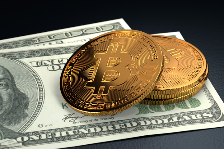 Small stack of Bitcoins on top of Benjamins