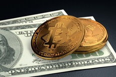 Small stack of Bitcoins on top of Benjamins