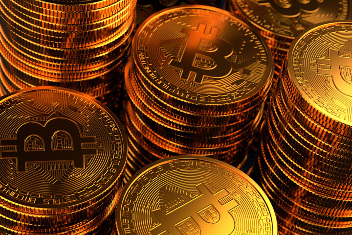 Top view on multiple stacks of Bitcoin with cast golden lighting