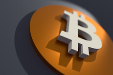 Angled view of orange and white Bitcoin B logo with short depth of field and spotlight