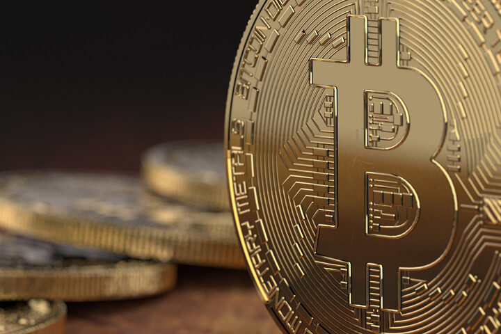 Close up view of Bitcoin on edge with blurred coins in background