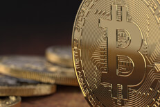 Close up view of Bitcoin on edge with blurred coins in background