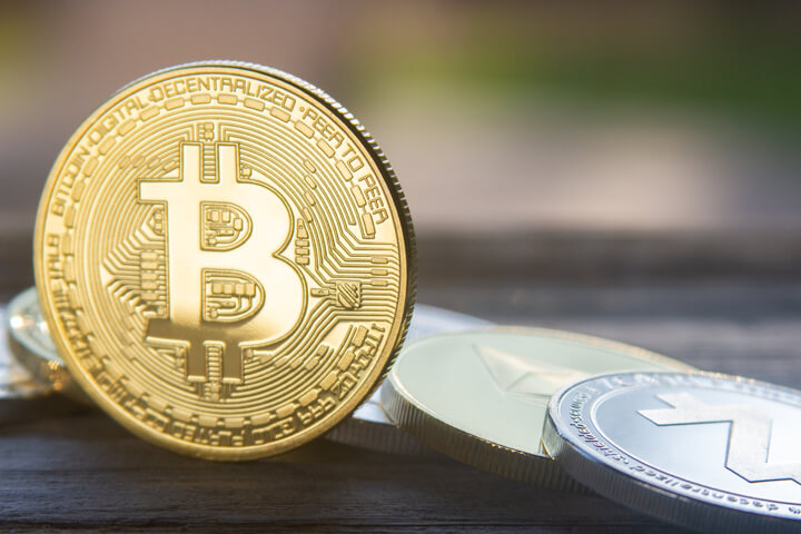 Bitcoin on edge in front of row including Zcash, Ethereum, Ripple, Monero, and Litecoin