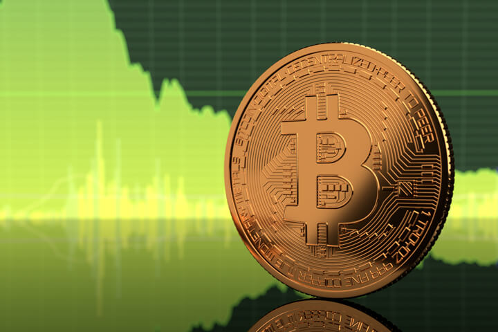 Bitcoin standing on edge on reflective surface with green BTC stock price area chart in background