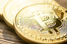 Detail photo of row of bitcoins on wood with backlight