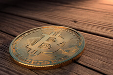 Single Bitcoin placed on weathered wood boards with upper right corner light