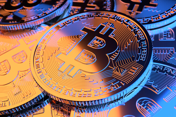 Pile of Bitcoins with gold and blue lighting representing hot and cold or Bitcoin stock price volatility