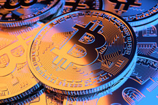 Pile of Bitcoins with gold and blue lighting representing hot and cold or Bitcoin stock price volatility