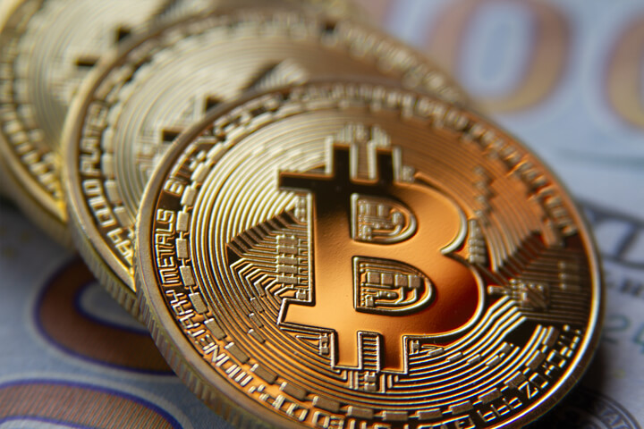 Bitcoins at angle on US 100 dollar bills