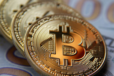 Bitcoins at angle on US 100 dollar bills