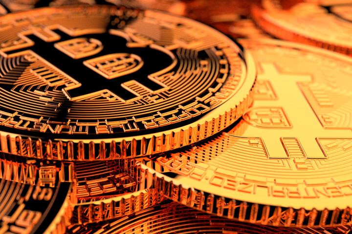 Random pile of Bitcoins with camera positioned low front with hard back lighting