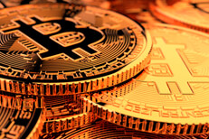 Random pile of Bitcoins with camera positioned low front with hard back lighting