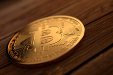 Single gold Bitcoin placed on stained wood planks with upper right soft light