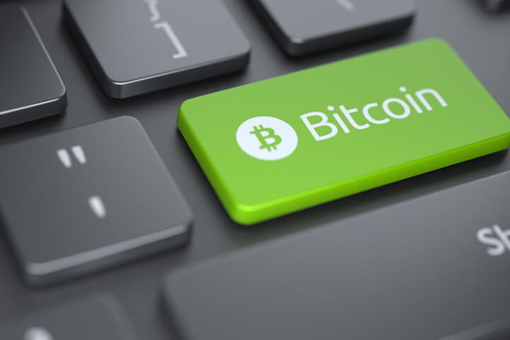 Computer keyboard with green Bitcoin key