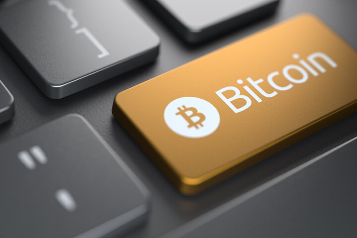 Computer keyboard with orange Bitcoin key highlighted with spot light