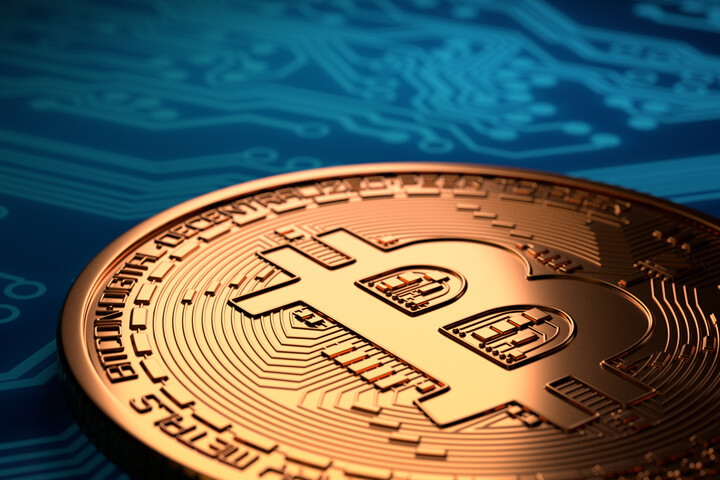 Single Bitcoin with hard spot light laying on blue circuit board