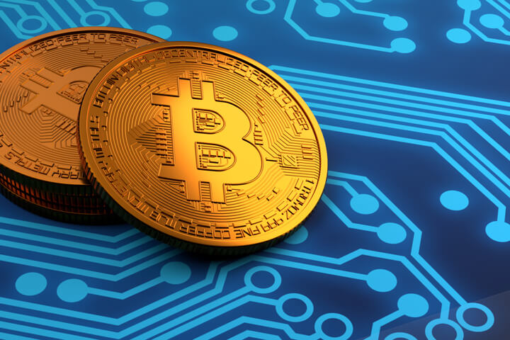 Small stack of Bitcoins with highlight on blue circuit board