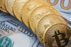 Bitcoins in a curved row on top of US 100 dollar bills