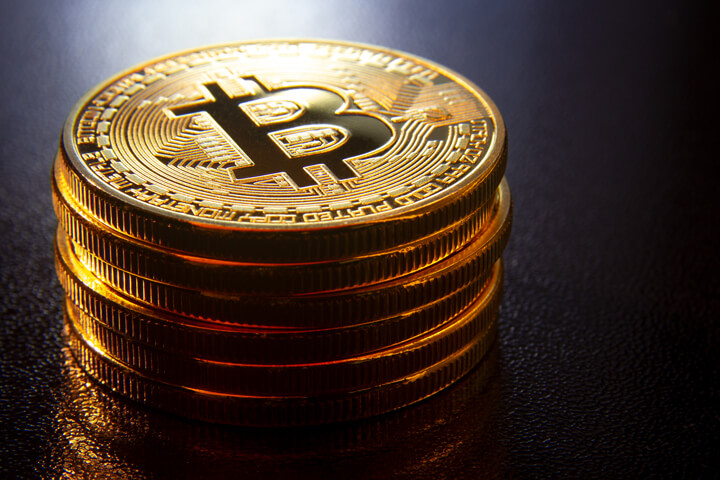 Stack of Bitcoins on reflective textured surface