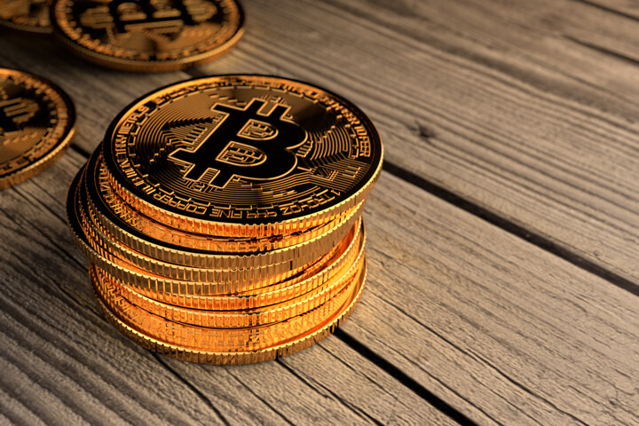 Stack of Bitcoins with scattered coins on weathered wood planks