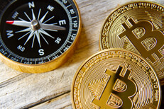 Navigational compass with two shiny Bitcoins on weathered wood