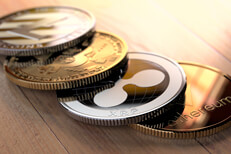 Curved row of cryptocurrency coins on wood floor