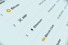 Computer monitor screenshot of cryptocurrencies showing Bitcoin, XRP, Ethereum, Bitcoin Cash, and Stellar logos with market cap values