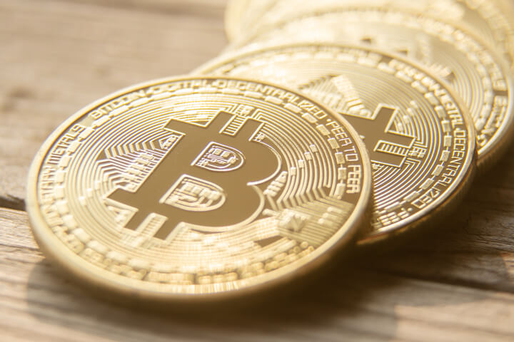 Curved row of Bitcoins on a blurred wooden background