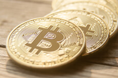 Curved row of Bitcoins on a blurred wooden background