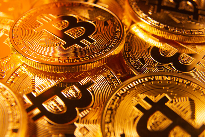 Pile of scattered bitcoins with gold lighting