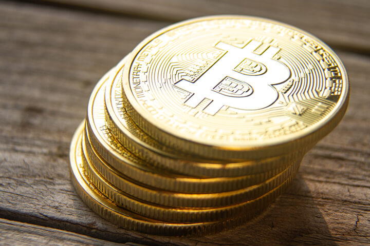 View from top of leaning stack of bitcoins on wood plank background