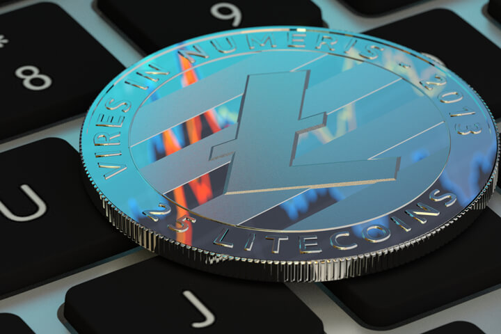 Free photo of Litecoin cryptocurrency token on laptop keyboard reflecting stock price area chart