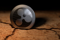 Ripple crypto coin stuck in crack left from dry desert mud