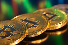 Row of Bitcoins reflecting stock price chart in computer monitor