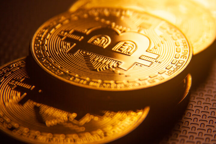 Bitcoins stacked in order with golden light from back