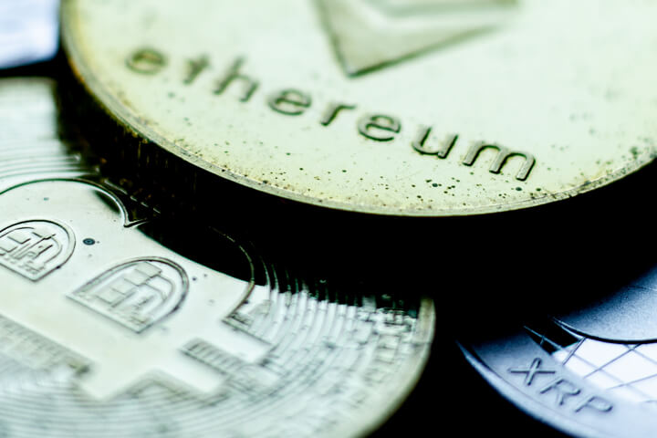 Tarnished Ethereum, Bitcoin, and XRP coins close up photo showing sharp contrast and metal tarnish