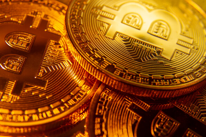 Three gold bitcoins with spotlight focus