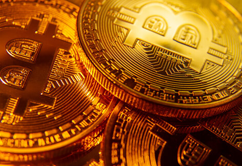 Three gold bitcoins with spotlight focus
