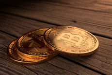 Three Bitcoins stacked in a row on stained wood planks
