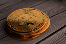 Stack of three Bitcoins resting on weathered wood planks