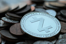Zcash cryptocurrency coin on pile of assorted tarnished U.S. currency coins with sharp depth-of-field blur