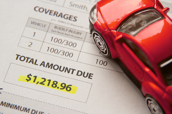 Toy car on auto insurance billing statement showing amount due