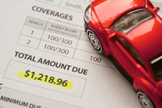 Toy car on auto insurance billing statement showing amount due