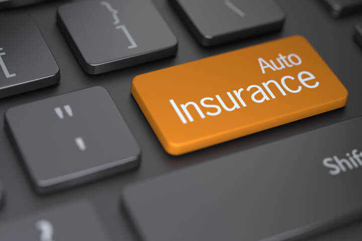 Laptop keyboard with large orange auto insurance key concept for buying auto insurance online
