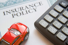 Auto insurance policy with calculator and small red toy car