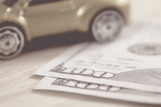 Grayscale version of toy car with cash Greyscale version of toy car on wood desk with two one hundred dollar bills