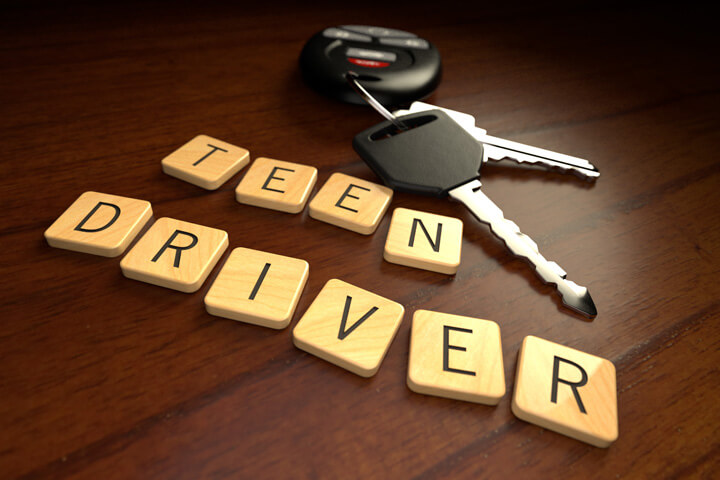 Teen driver in wooden letters with car keys on wooden desk